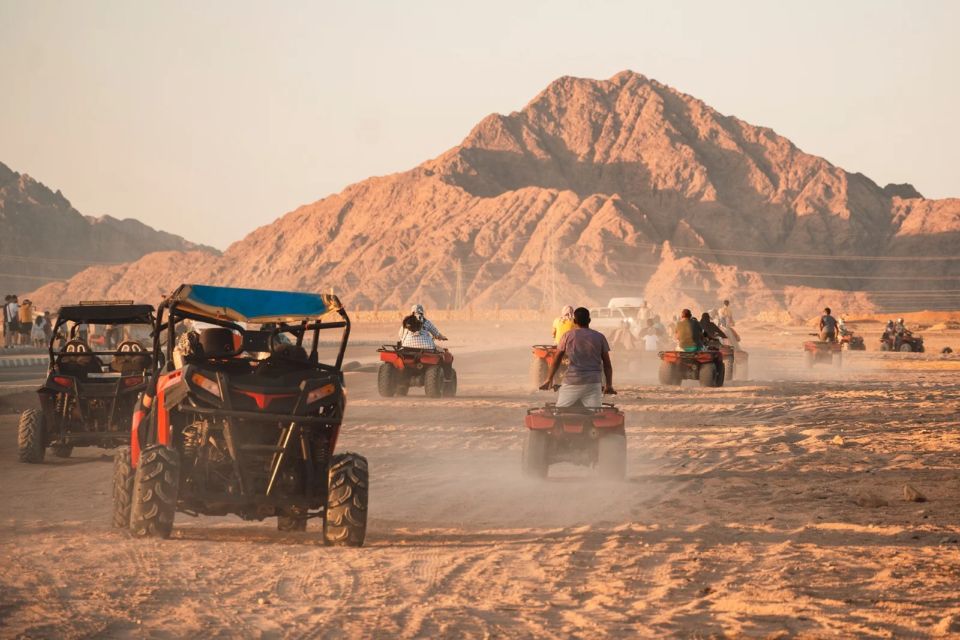 Quads en buggy's rijden in het licht van de late middag door de woestijn bij Sharm El Sheikh, met bergen op de achtergrond.
