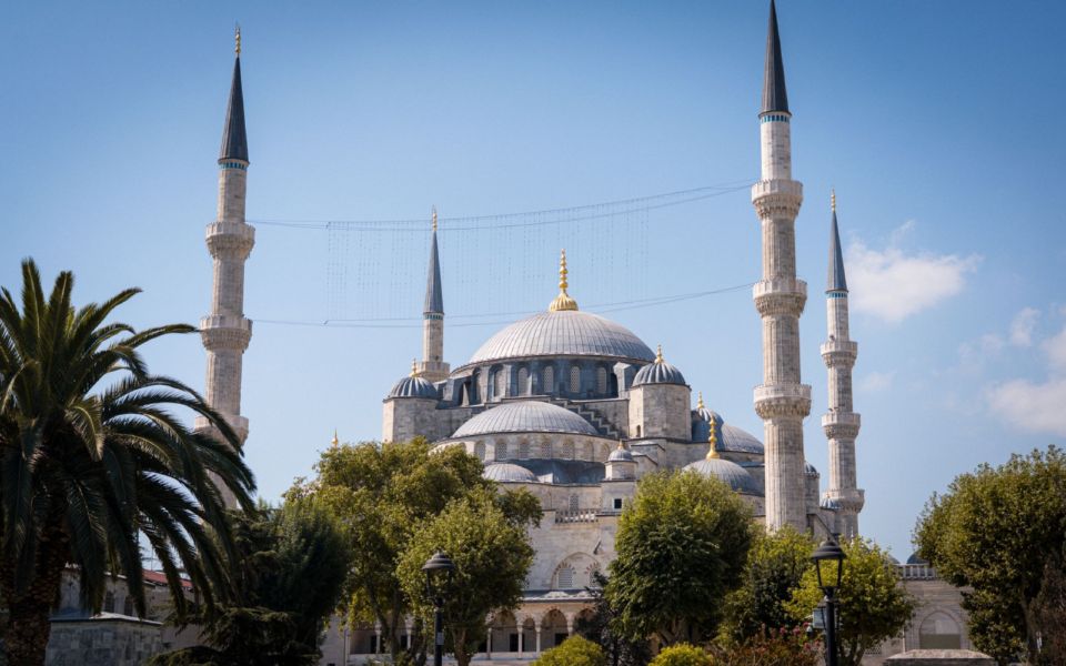 De Blauwe Moskee in Istanbul, gezien vanuit de tuinen met zijn koepels en minaretten onder een heldere lucht.