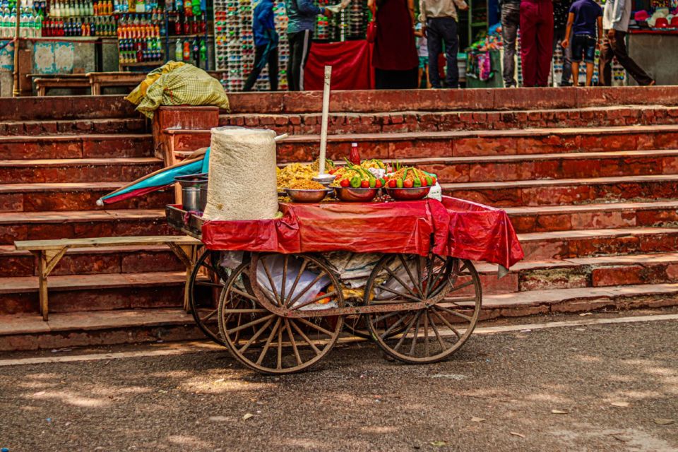 Un carretto di street food con ciotole di condimenti vicino a una scalinata a Chandni Chowk, Delhi.