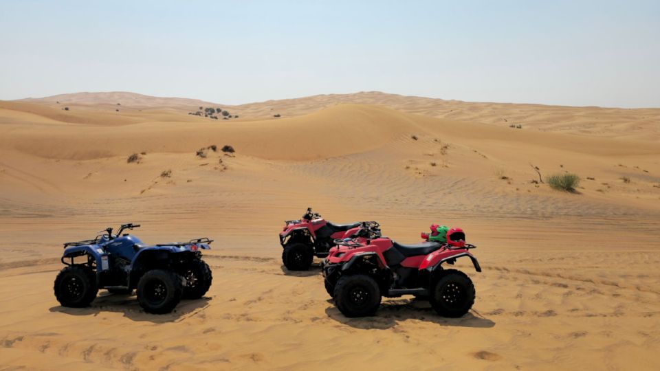 Three quad bikes parked on sandy desert dunes near Agadir in daylight.
