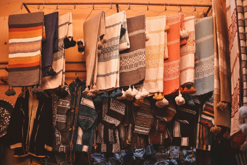 Tradicionalni tkani tekstil i jakne vise na prodaju u jednoj tezgi na pijaci u Agadiru.