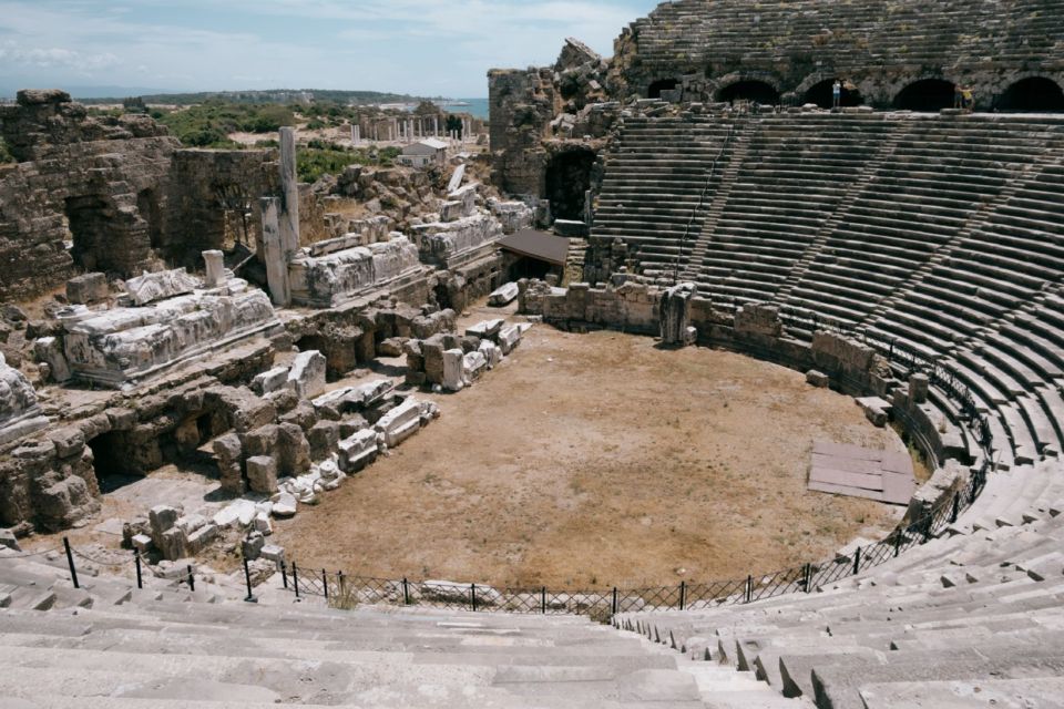 The ancient theatre at Side in Antalya, with tiered stone seating and ruins beyond