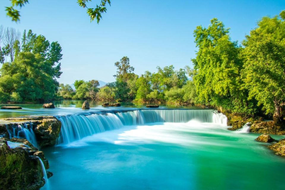 Manavgat Waterfall near Side, Turkey, with wide cascades flowing into turquoise water on a sunny day.