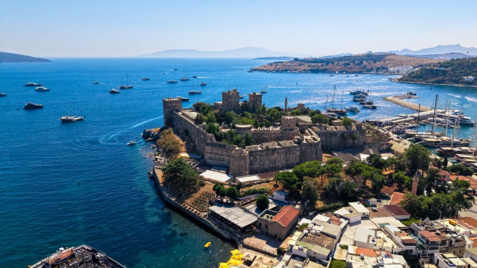 Bodrum Castle of St Peter on its headland, surrounded by the Aegean Sea with boats moored nearby.