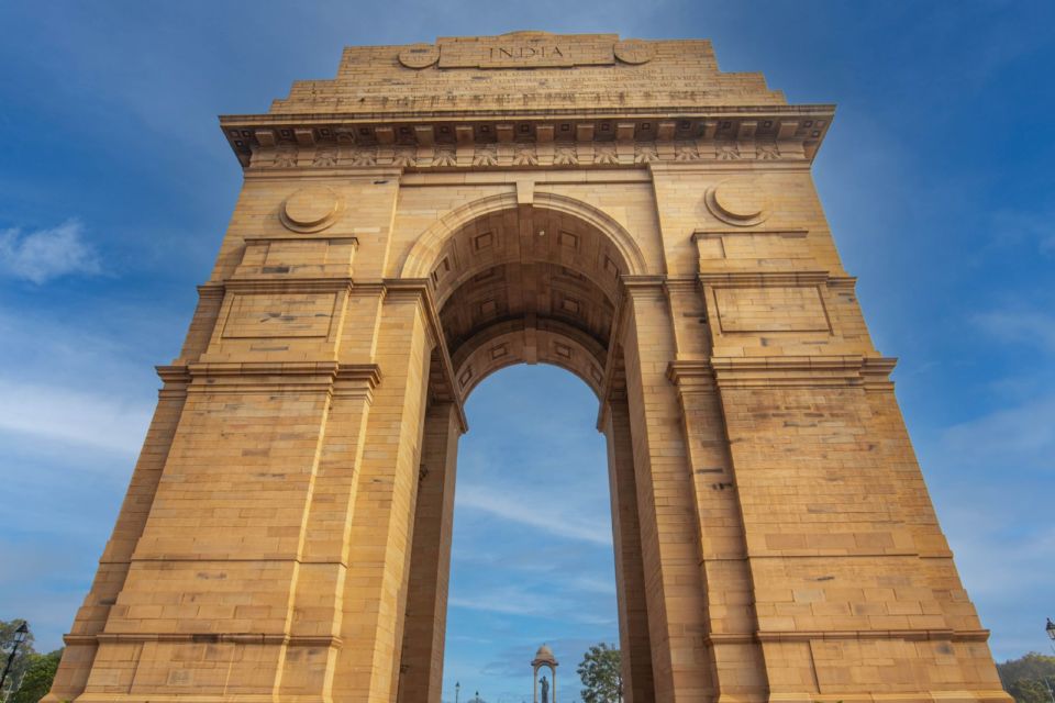 India Gate in New Delhi seen from below against a clear blue sky.