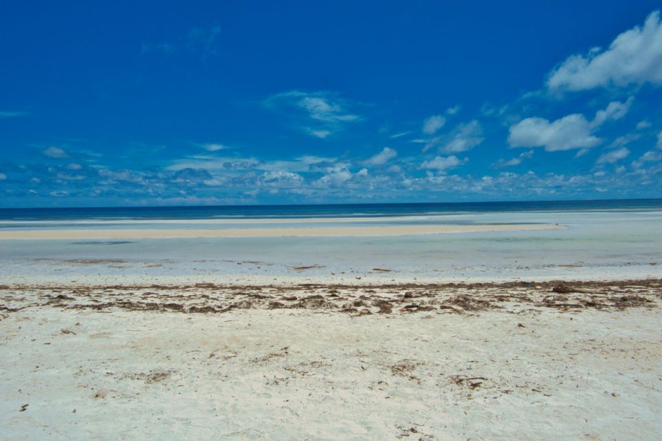 Sandy beach and shallow tide at Nungwi, Zanzibar, under a clear blue sky