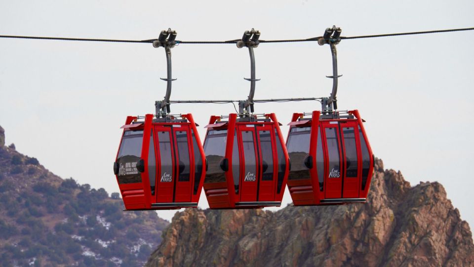 Red cable car gondolas carry visitors up toward the Agadir kasbah on the hillside.